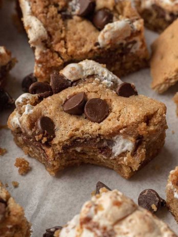 Several s'mores bars on a piece of white parchment paper.