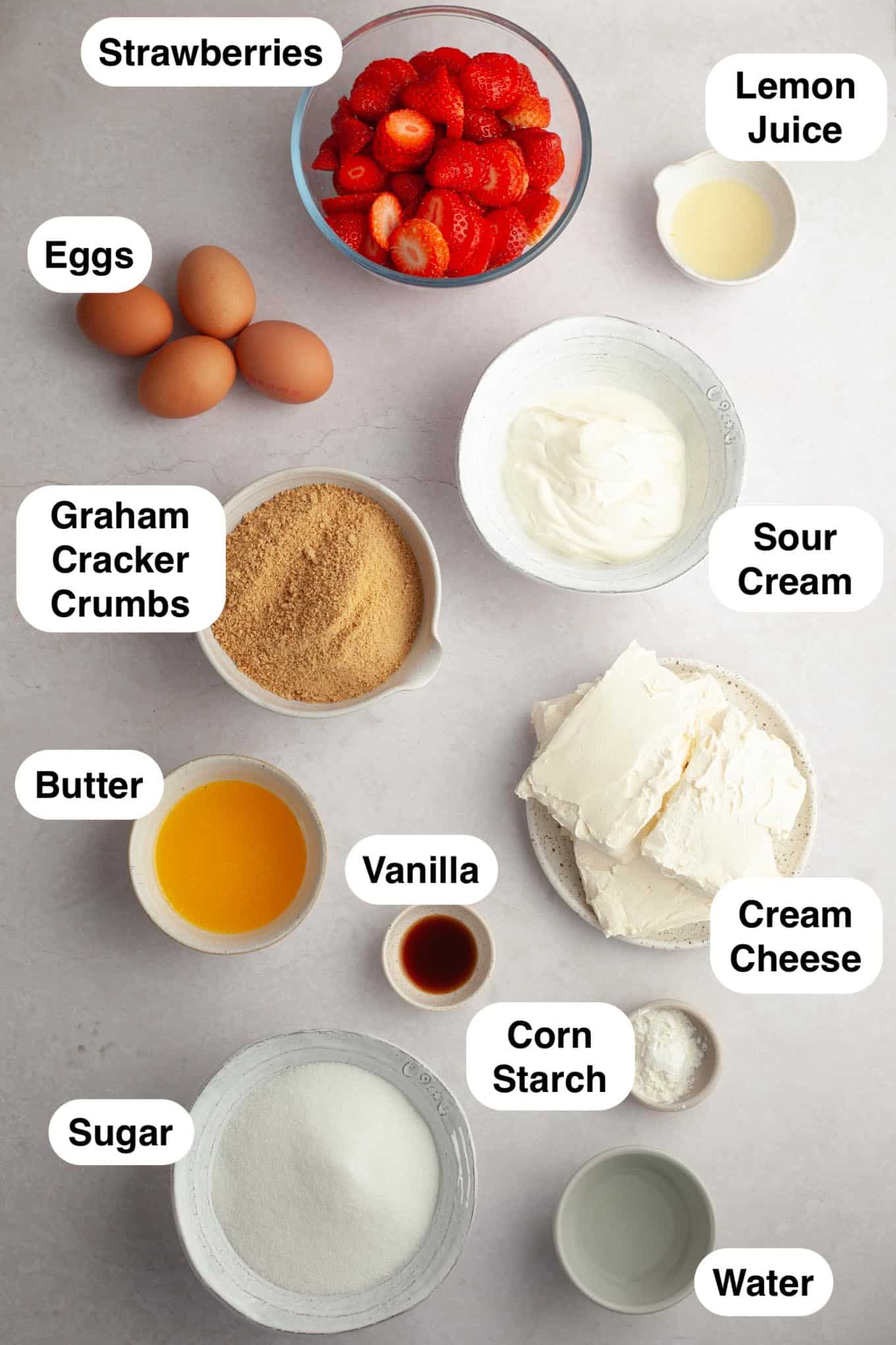 An overhead view of the ingredients for a strawberry cheesecake.