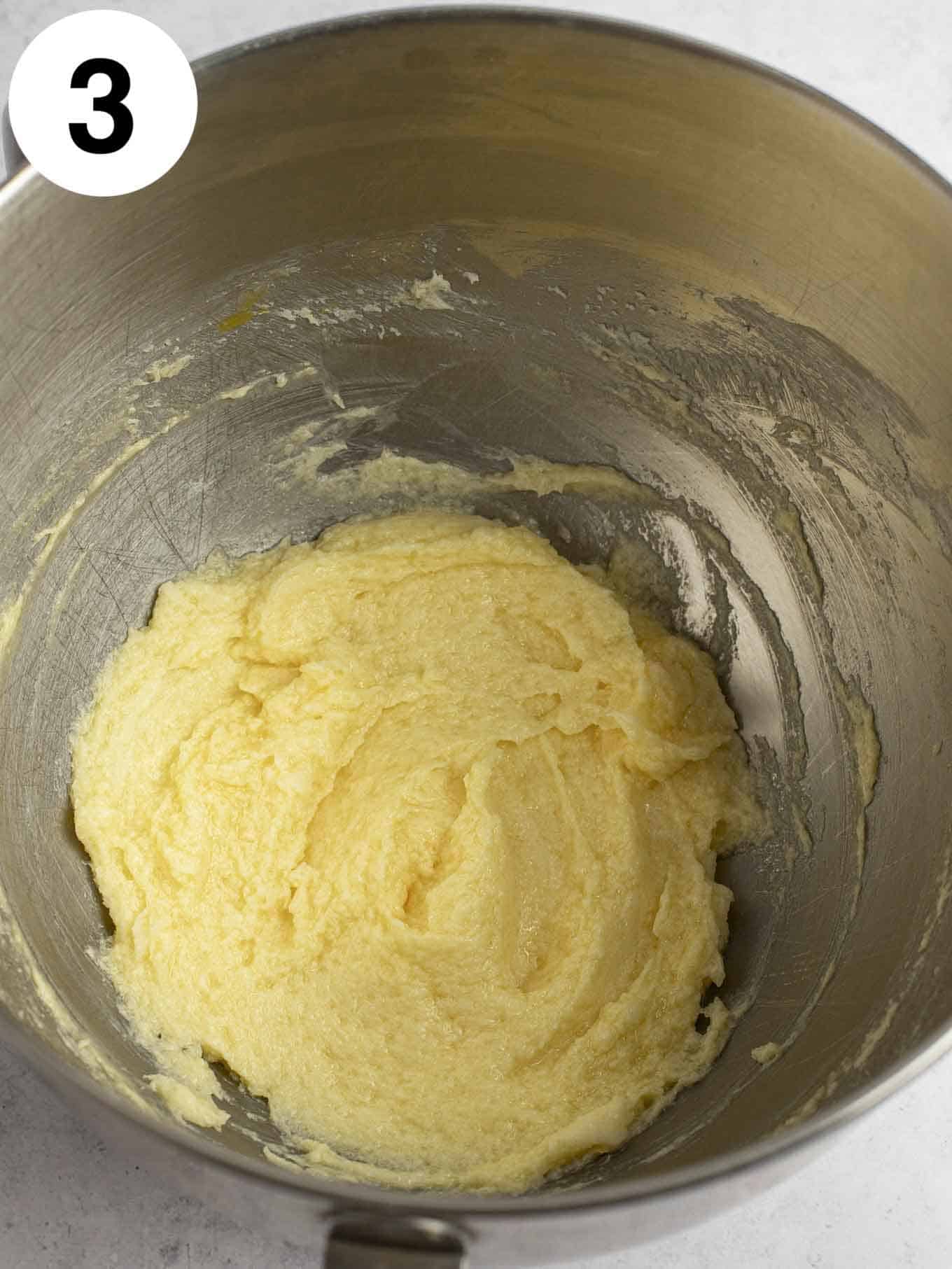 An overhead view of creamed butter and sugar in the bowl of a stand mixer. 
