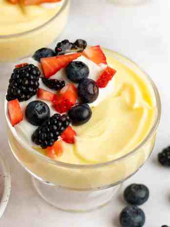 A bowl of vanilla pudding topped with fresh berries.