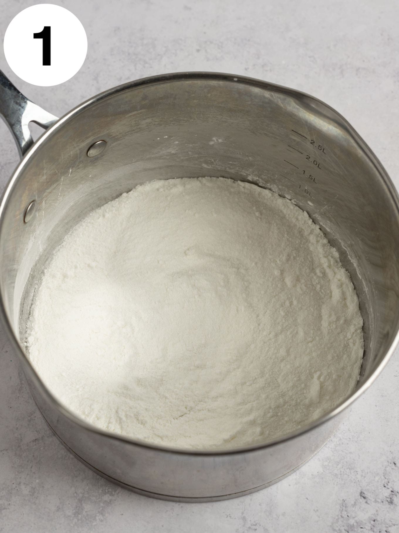 An overhead view of cornstarch and granulated sugar in a saucepan. 