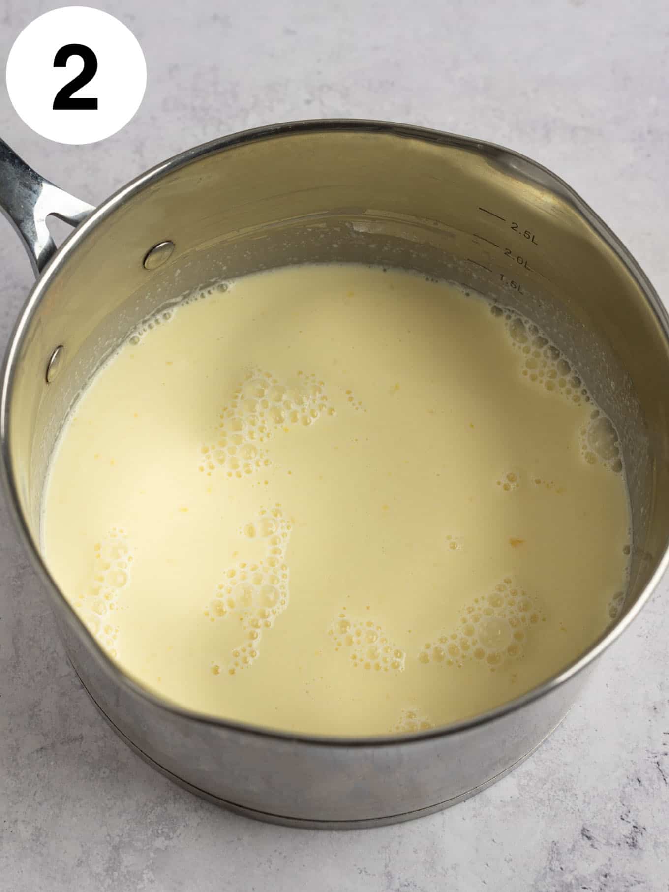 An overhead view of uncooked vanilla pudding ingredients in a saucepan. 