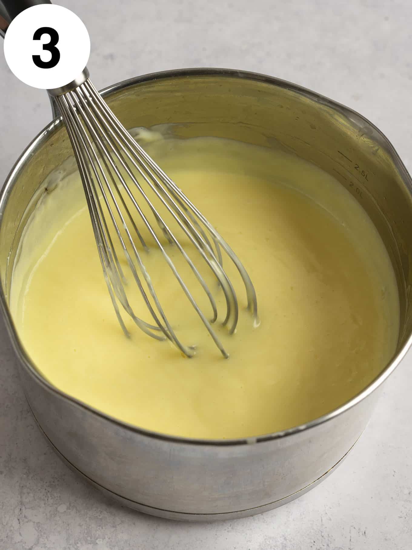An overhead view of cooked vanilla pudding in a saucepan. 