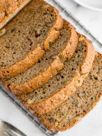 A sliced zucchini bread on top of a marble surface.